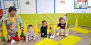 Escola Infantil Apolo 10 maestra con bebés en salón decorado