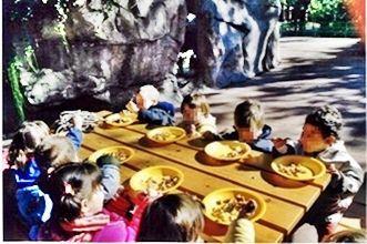  niños comiendo al aire libre