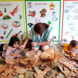 Escola Infantil Apolo 10 niños y maestra sobre hojas de otoño