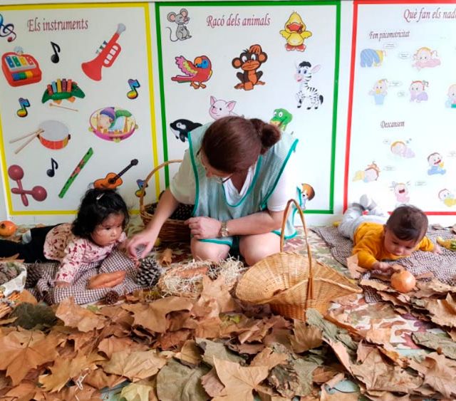 Escola Infantil Apolo 10 niños y maestra sobre hojas de otoño