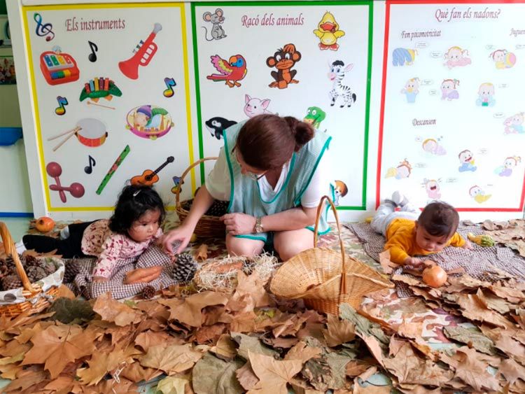  niños y maestra sobre hojas de otoño
