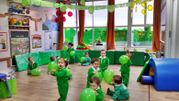 Escola Infantil Apolo 10 niños felices en fiesta de color verde
