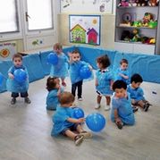 Escola Infantil Apolo 10 niños felices en fiesta de color azul