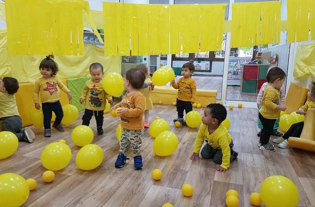  niños con globos amarillos